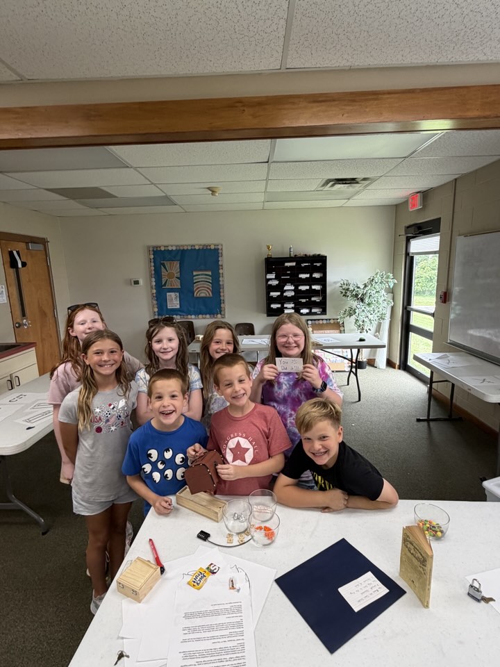 A group of campers smiling with a solved puzzle box