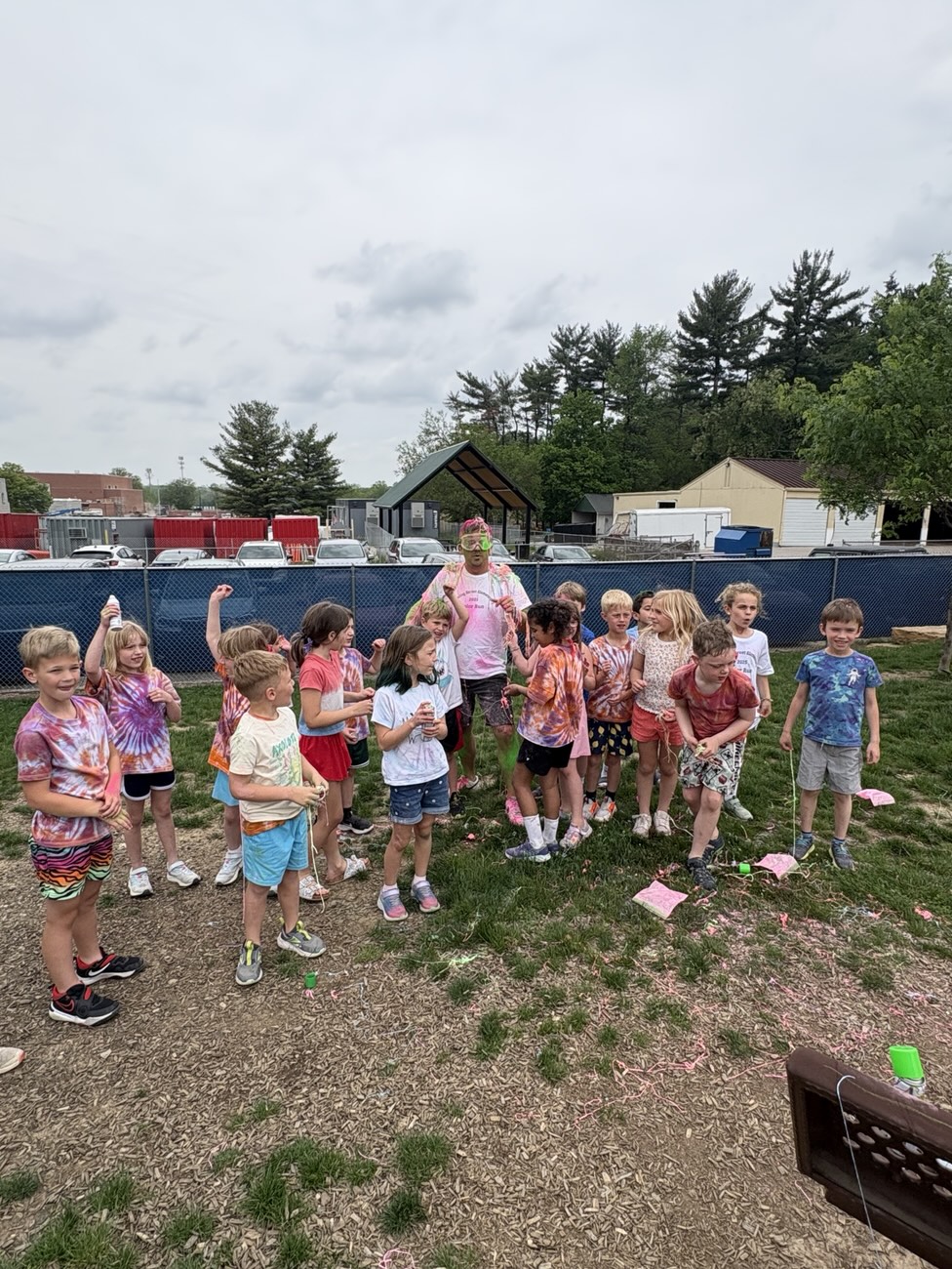 Students in tie-dye shirts having fun outdoors at a TopKid event